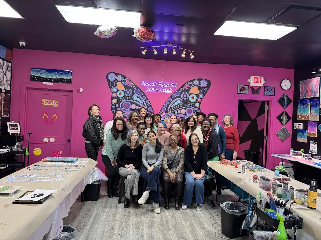 Colleagues showing off colorful fluid art paintings in studio