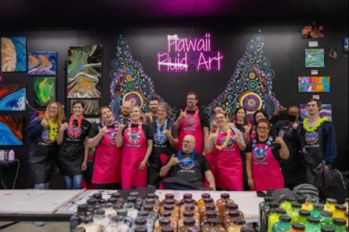 Attendees holding custom fluid art paintings at a baby shower