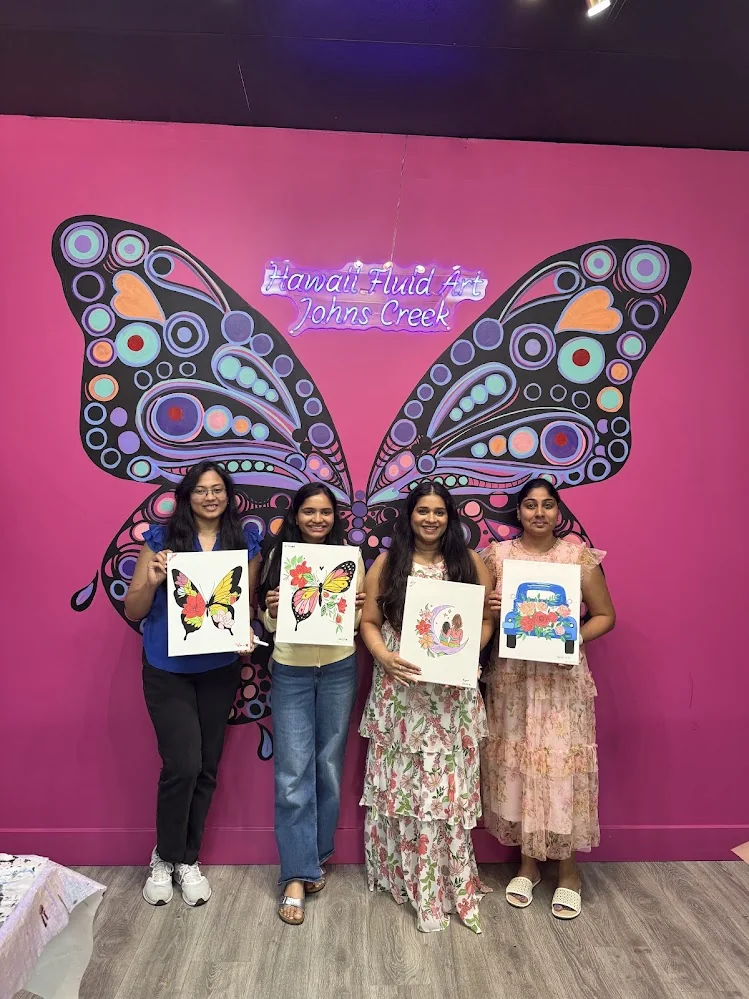 Proud kitty party attendees showcasing their finished canvas painting masterpieces in Johns Creek