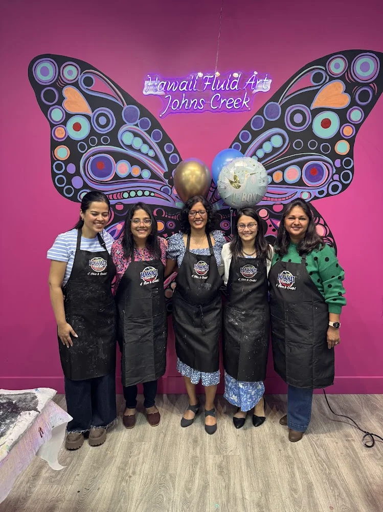 Group of friends wearing aprons celebrating a colorful kitty party event in Johns Creek GA