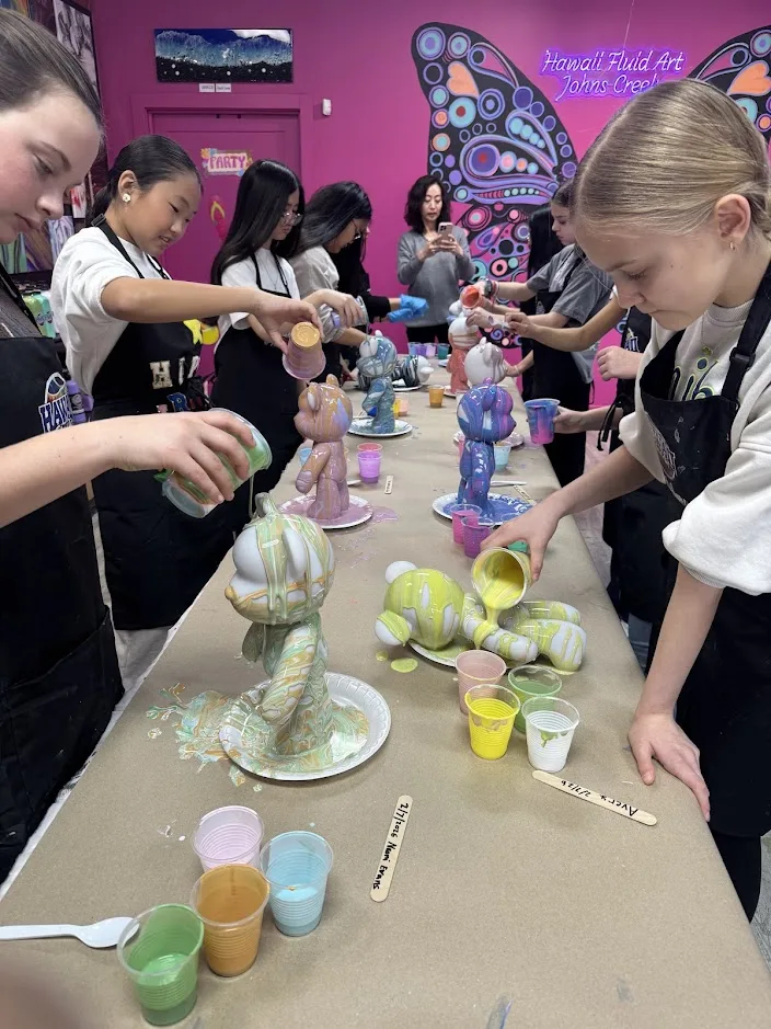 Teens painting custom drip bear figurines in our Johns Creek studio